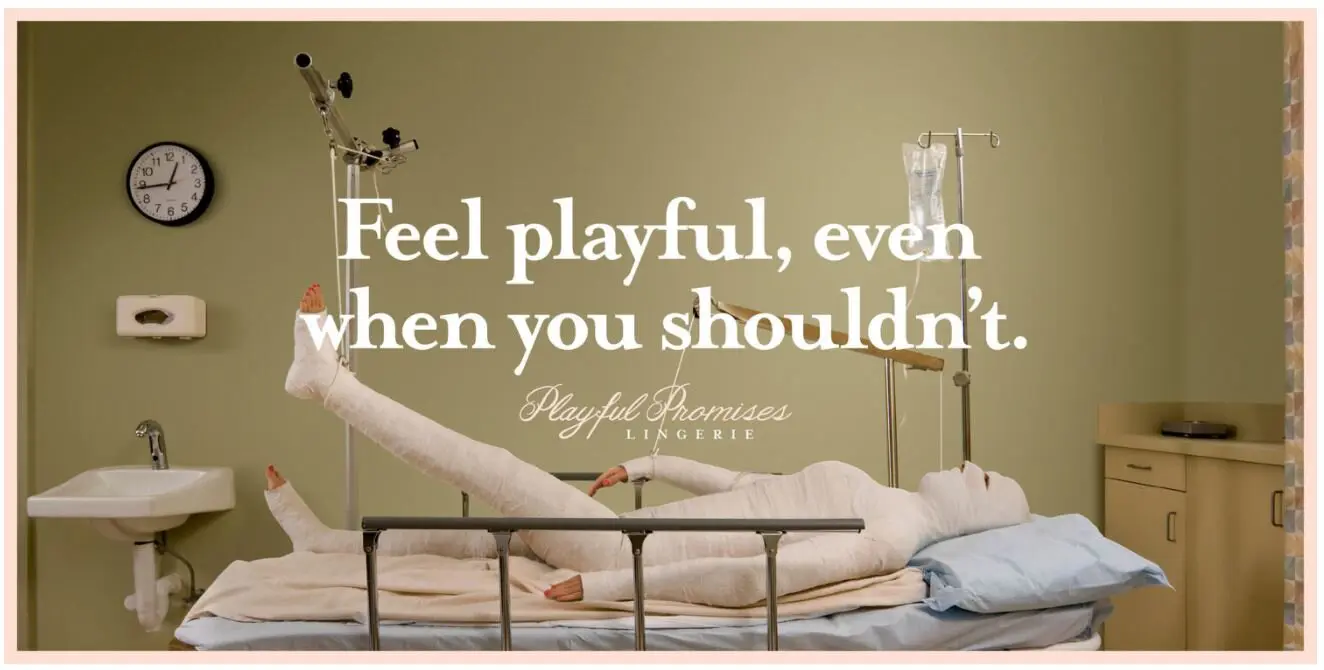 Playful promises Lingerie ad campaign - picture of someone in a hospital bed wrapped up in bandages with the wording 'Feel playful, even when you shouldn't.'