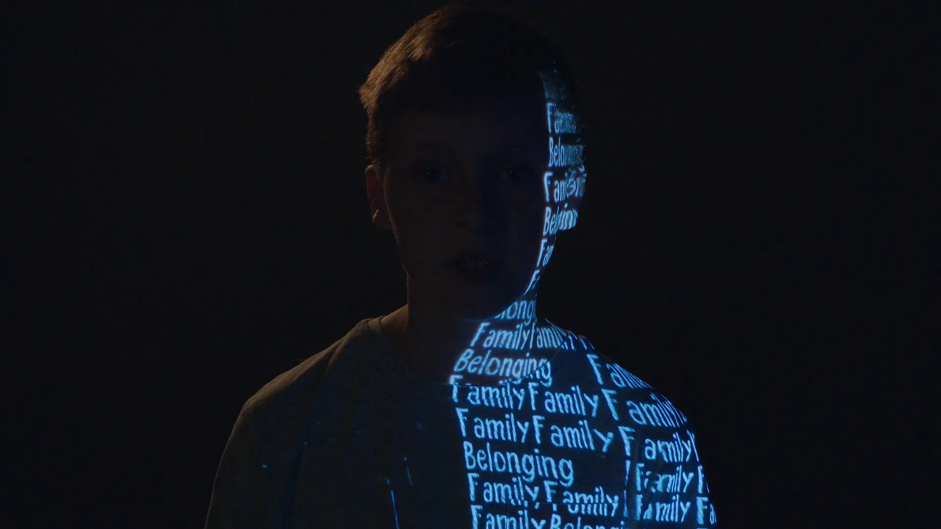 Young boy with the words Family and Belonging projected down one side of his body.