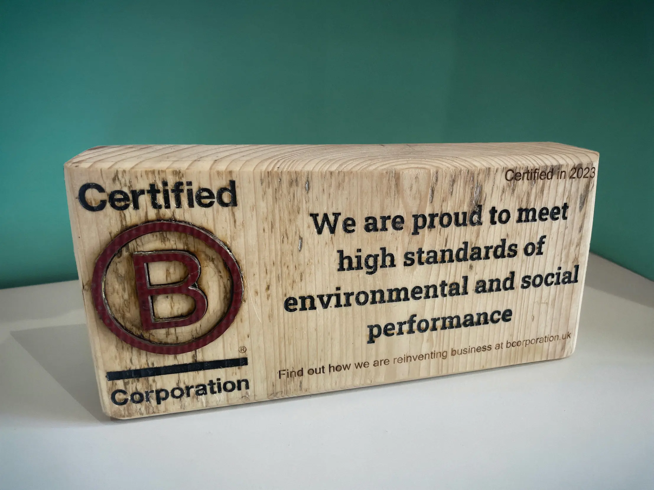 Certified B Corporation wooden block with the words 'We are proud to meet high standards of environmental and social performance'